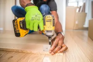 a person using a drill to drill a piece of wood